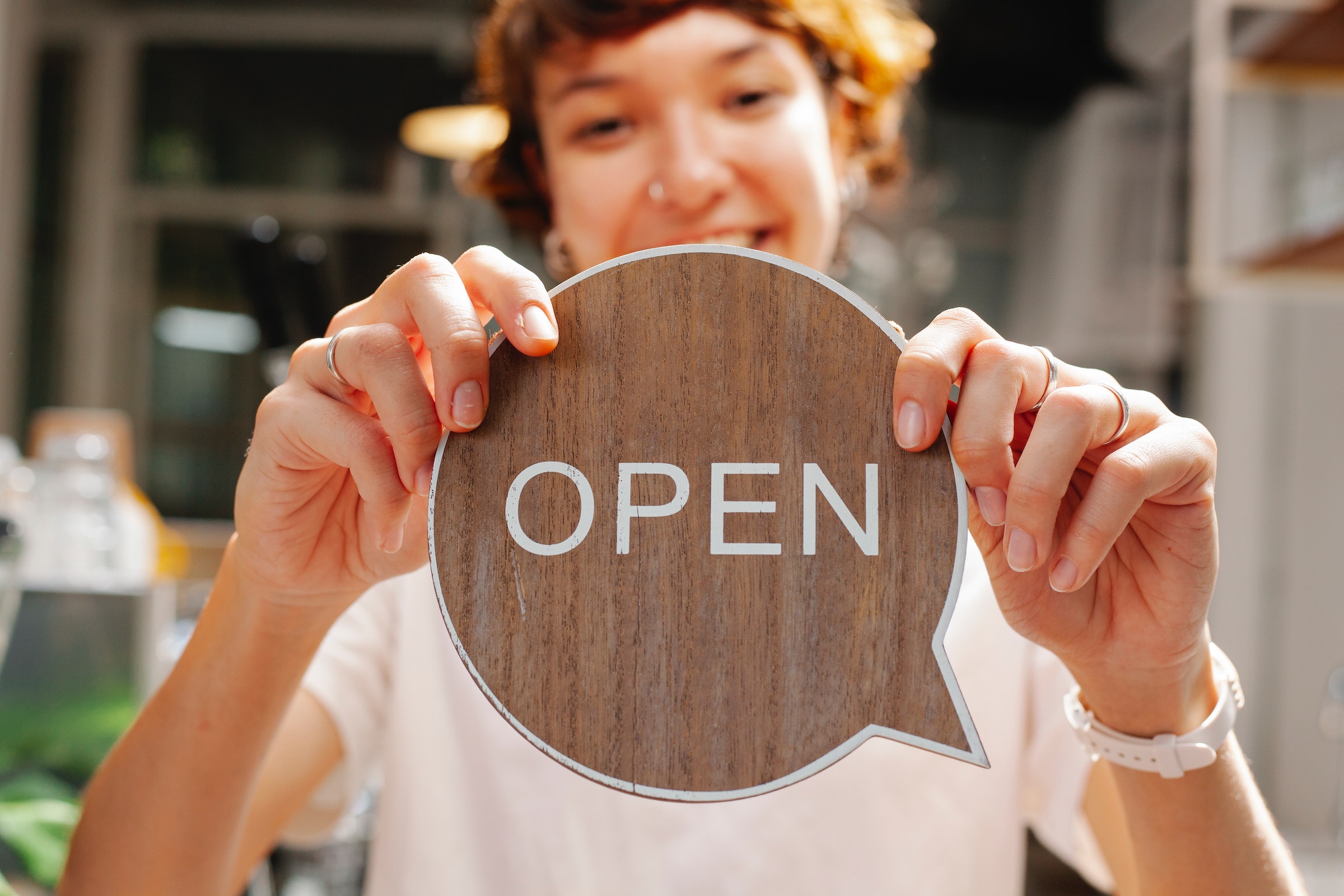 Preheader - dame avec un panneau Open en bois