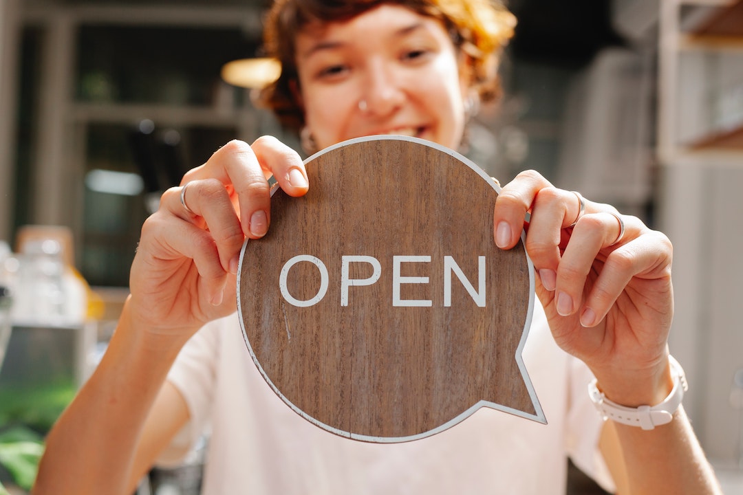 Preheader - dame avec un panneau Open en bois