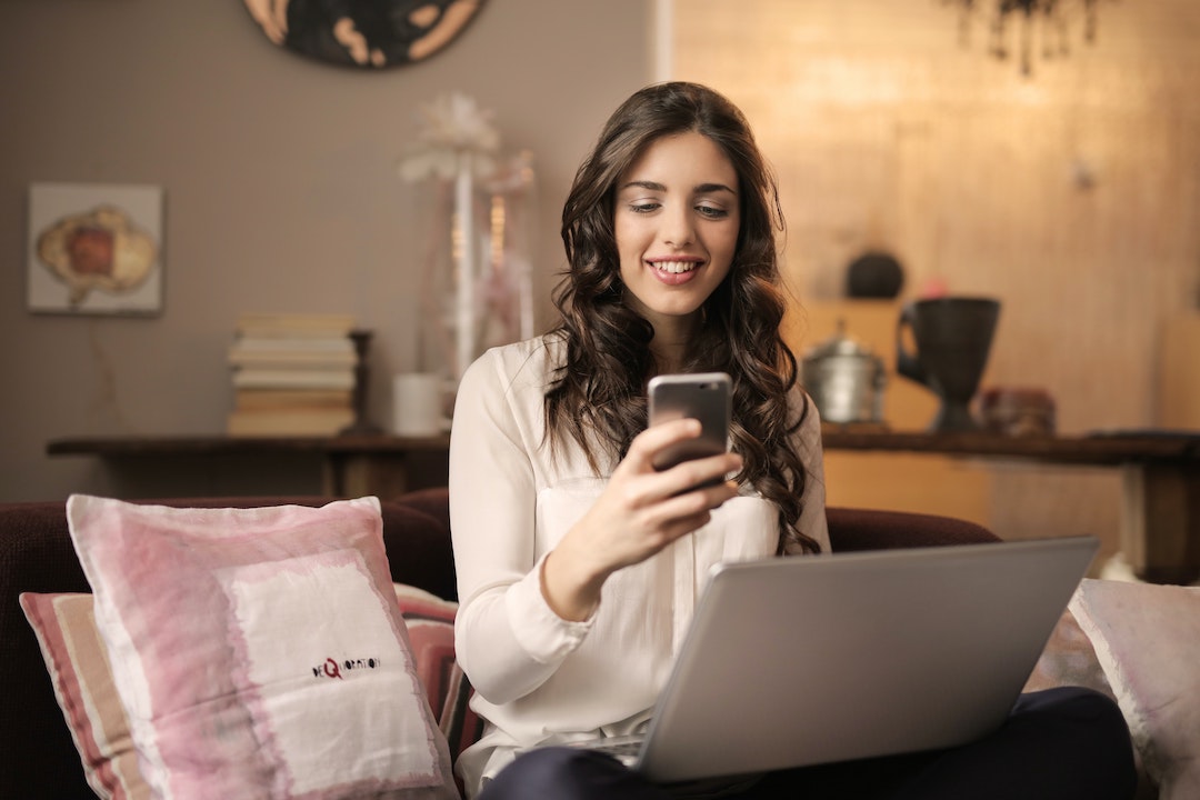 Image d'une femme souriant à son téléphone - photo d'Andrea Piaquadio - Pexels