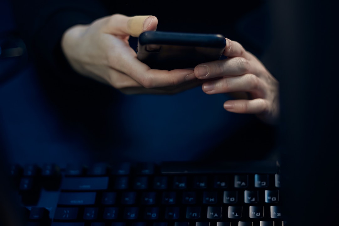 Mode sombre - Photo d'une personne avec un téléphone noir et un clavier noir