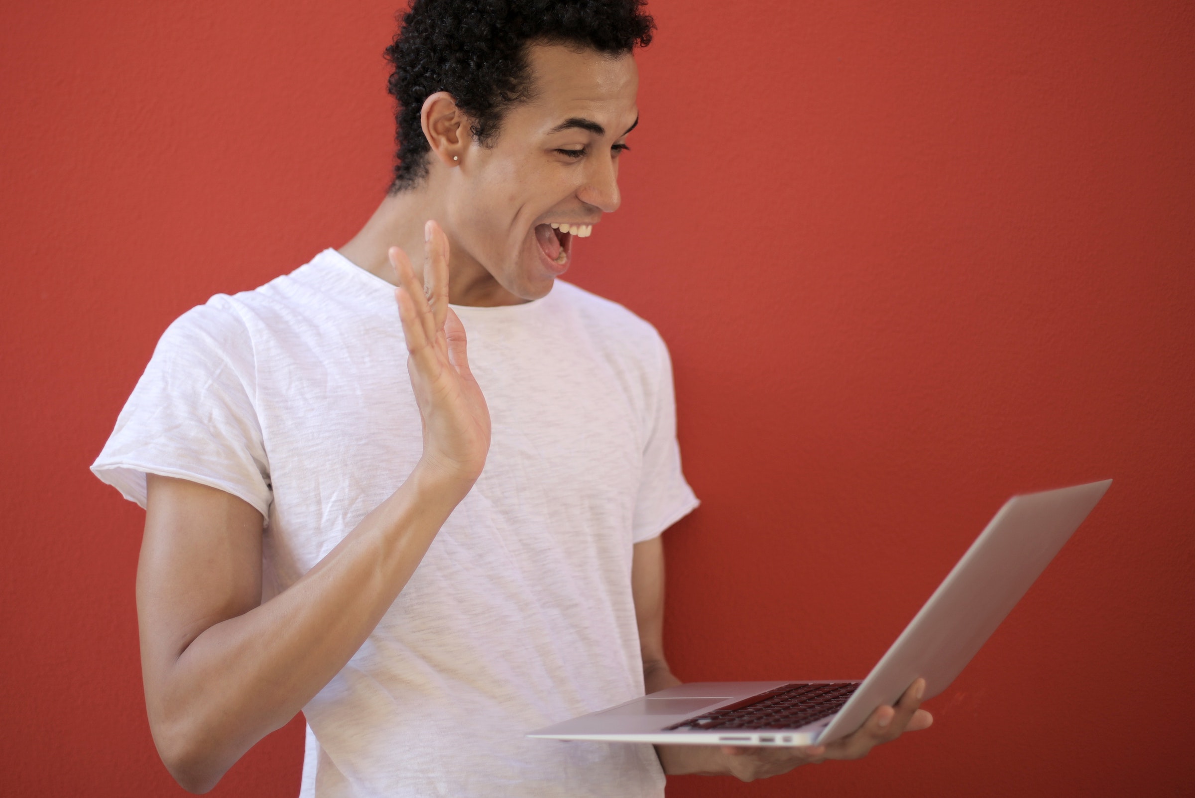 Homme souriant devant un ordinateur heureux de voir son email personnalisé - Photo par Andrea Piacquadio - Pixels