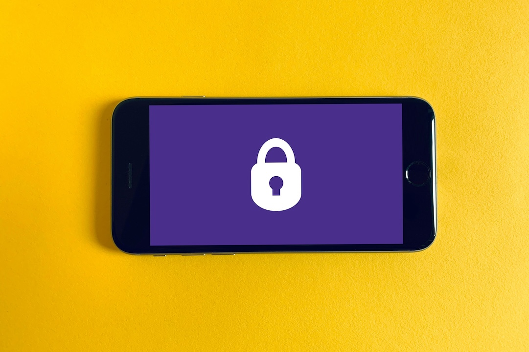 Iphone noir sur fond jaune avec un cadenas. Photo de Franck sur Unsplash